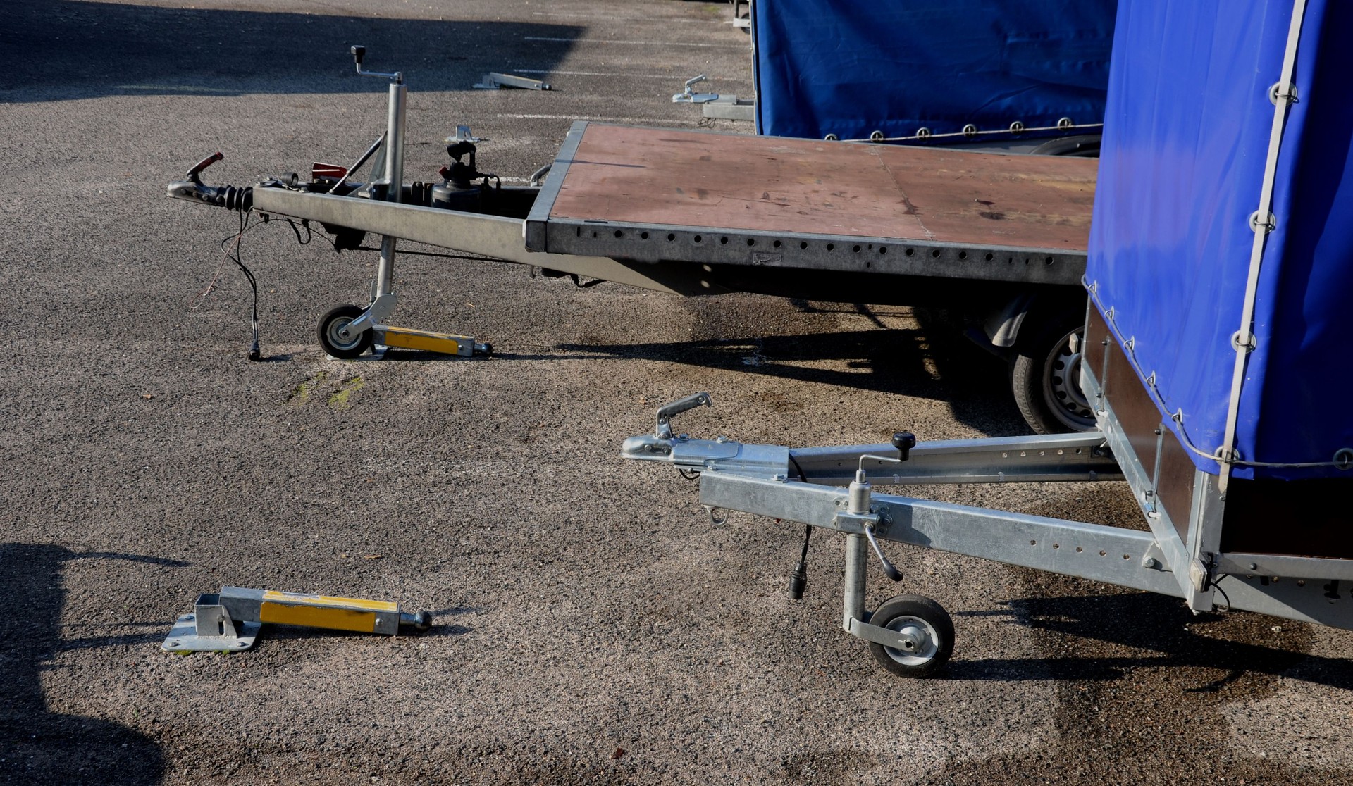 lockable parking lot for trailers behind a car or pickup truck. the end of the towing device on the tipping post attached to the road. a tow truck, a truck tarpaulin and an ordinary body with sides